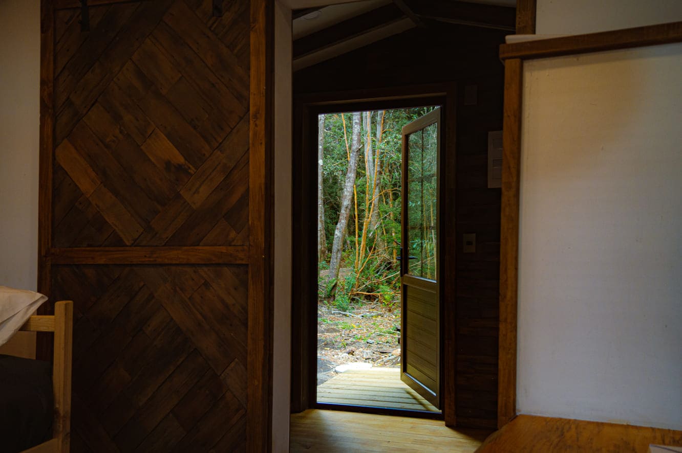 Interior cabaña Travesía Austral — madera nativa y bosque